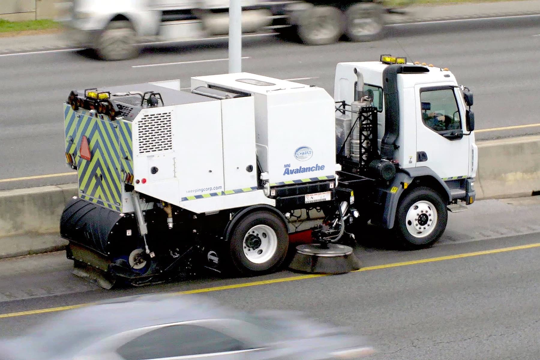 A Schwarze street sweeper working along a highway shoulder